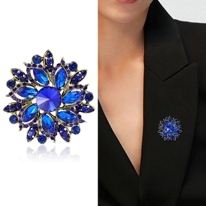 Royal blue crystal flower brooch with vintage gold finish on a black suit jacket