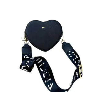 Fashionable black heart-shaped leather crossbody bag with trendy wide logo shoulder strap