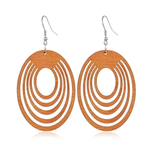 Detail view of coffee-colored hollow oval wooden earrings with concentric geometric patterns