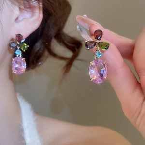 Macro shot of colorful zirconia teardrop earrings featuring a large pink oval gemstone