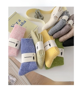 Close-up of ribbed wool blend socks in various colors with elegant paper packaging labels