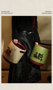 Detail of creative cream trash bin with red handles and festive Chinese calligraphy