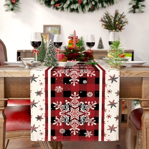 Christmas table runner with red and black plaid pattern and white snowflake prints