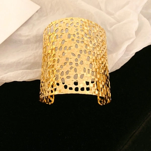 Detailed view of gold-plated wide cuff bracelet with intricate hollow woven mesh design