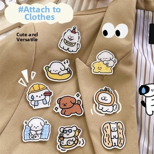 Detailed embroidery texture of nine cartoon dog patches on a khaki suit jacket