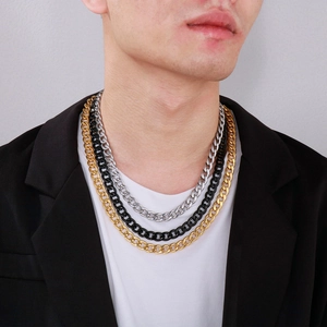 Close-up of stacked Cuban link chains for men in gold, silver, and black finish