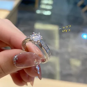 Close-up of a classic six-prong sparkling diamond ring with a pavé-set silver band