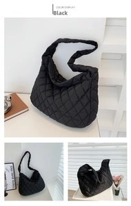 Macro view of black quilted crescent bag detailing classic diamond stitching and puffy texture