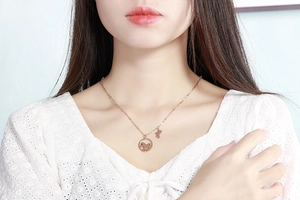 Collier en or rose avec un pendentif circulaire motif poney porté par un mannequin