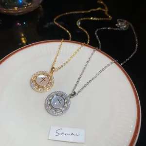 Détail du collier croix plaqué or 18K avec nacre et zircons brillants incrustés