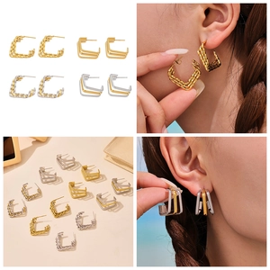 Macro view of multi-layer C-shape stainless steel hoop earrings with textured finish
