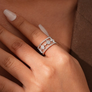 Dettaglio ravvicinato di un anello largo in argento con motivi a stella in zircone