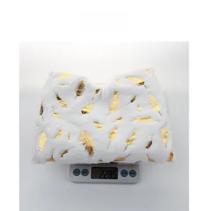 Weight measurement of white faux fur Christmas tree skirt with gold feathers, 228.5 grams