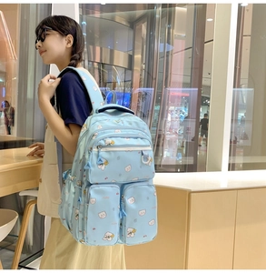 Detail view of the light blue bear backpack showing side pockets and padded shoulder straps