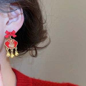 Detail of red bow earring with golden Ruyi lock charm and three small jingling bells
