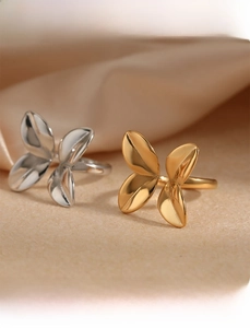 Macro detail of petal-shaped stainless steel rings in polished gold and silver finishes