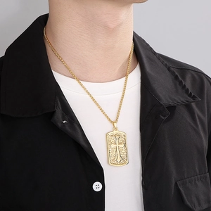 Close-up of gold cross military tag pendant on a wheat chain worn by a male model