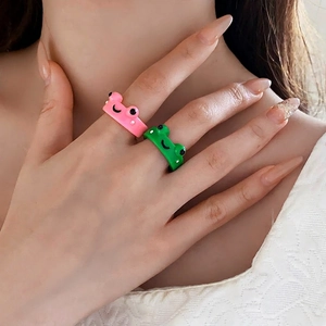 Cute cartoon frog open rings in pink and green colors worn by a female model