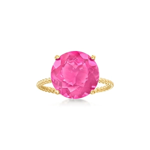 Macro view of four-prong gold ring featuring a large pink gemstone and twisted band