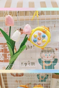 Close-up of yellow duck fidget toy with colorful silicone buttons and yellow hanging strap