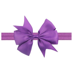 Detail of purple grosgrain ribbon bow on elastic baby headband against white background