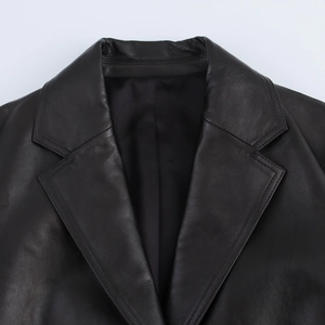 Close-up of the notch lapel and shoulder stitching on a black faux leather jacket