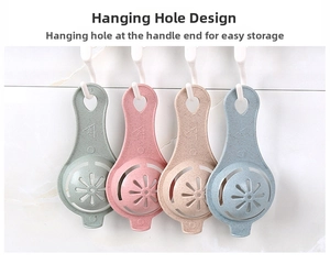 Four colorful egg white separators hanging on a white tiled wall for easy storage