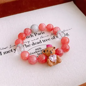 Bracelet en perles rose pêche avec pendentif ours mignon tenant un coeur en zircon