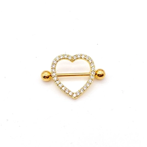 Macro detail of golden heart nipple ring shield with sparkling zircon inlay