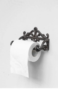 Détail d'un porte-rouleau en fonte vintage avec motifs sculptés sur mur blanc