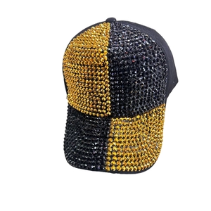 Detailed close-up of checkerboard gold and black rhinestones on a stylish baseball cap