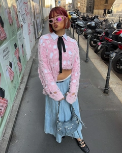 Outdoor street style shot of pink hollow-knit sweater and blue denim shoulder bag
