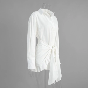 Detail of white cotton shirt dress featuring waist wrap tie and side profile silhouette
