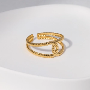 Gros plan sur la texture torsadée dorée d'une bague ajustable en acier inox