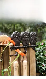 Close-up of three vintage cast iron owl wall hooks with detailed feather textures
