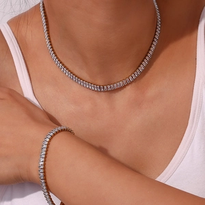 Detail of luxury gold necklace and bracelet set with rectangular cut cubic zirconia stones