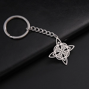 Detailed close-up of a silver Celtic knot pendant on a black leather background