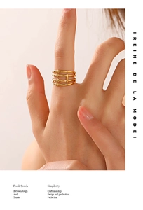 Close-up of a minimalist gold-plated multi-layer intertwined ring worn on a finger