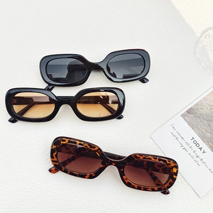 Oval vintage sunglasses in black, tea brown, and tortoiseshell displayed on a textured background