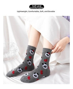 Detail shot of a grey cotton sock featuring cute panda and strawberry patterns with soft texture
