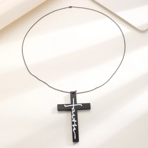 Macro view of matte black cross pendant with white faith engraving and bead chain