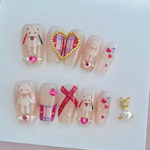 Relief nude pink press-on nails set with cartoon bunnies, pearls, and heart rhinestones