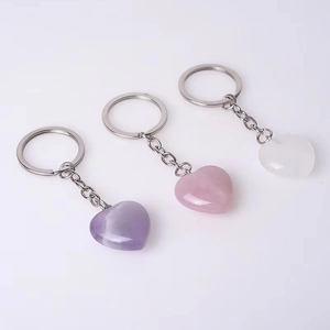 Close-up of polished heart-shaped crystal keychains in amethyst, rose quartz, and white