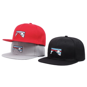 Close-up of embroidered mountain patch details on red, grey, and black snapback caps