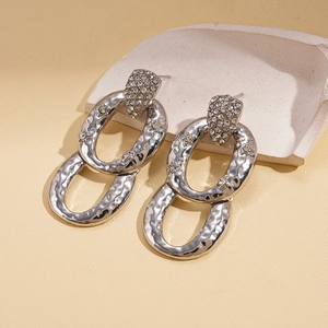 Detail of silver drop earrings featuring hammered texture and sparkling rhinestones