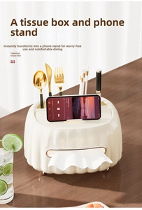 Close-up of cream tissue box with smartphone stand and golden cutlery storage compartments