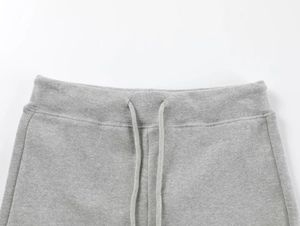 Detail of high-waist elastic waistband and grey drawstring on knitted yoga shorts