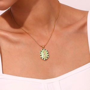 Detailed close-up of a Virgin Mary necklace pendant with green and white zircon inlays