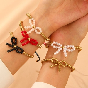 Elegantes Perlenschmuck-Set mit goldenen Metallperlen und bunten Schleifenanhängern