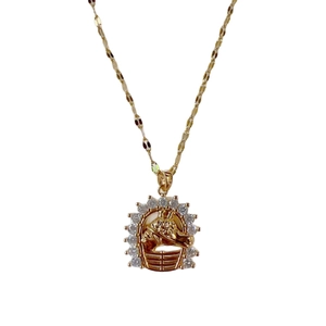 Elegant gold necklace featuring a circular horse head pendant with sparkling rhinestones